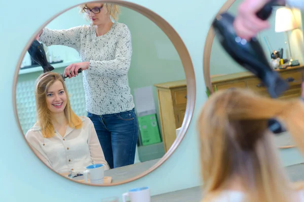 Piękna młoda kobieta patrząc w lustro do fryzjera — Zdjęcie stockowe