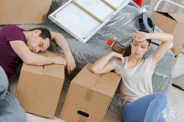 Couple fatigué se reposant dans une nouvelle maison pendant le déménagement — Photo