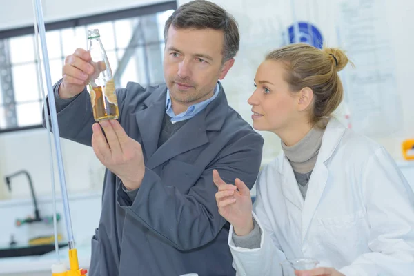 Cientistas que trabalham com líquidos no laboratório — Fotografia de Stock