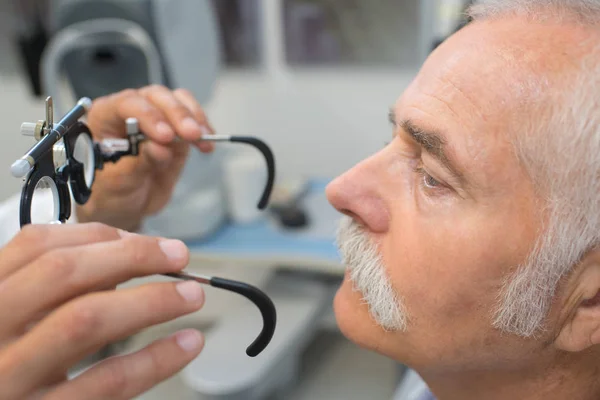 Optometrista control de la visión del paciente masculino senior — Foto de Stock