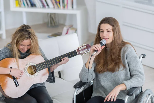 Девушка учит своего друга играть на гитаре — стоковое фото