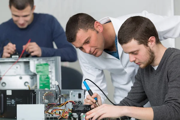Aprendiz técnico masculino soldando lan switch router — Fotografia de Stock