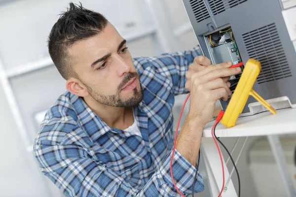 Engenheiro usando um testador de tensão e corrente — Fotografia de Stock