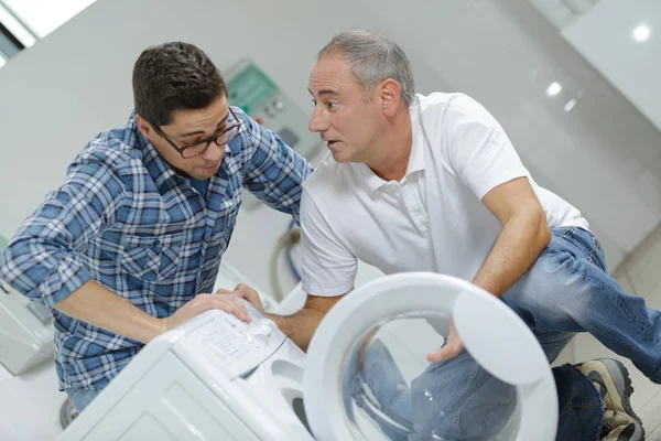 Apprentice and mentor working on laundry machine — Stock Photo, Image