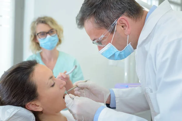 Dentist inspecting patient's teeth — Stock Photo, Image