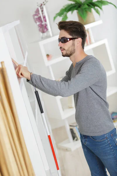 Aveugle avec bâton blanc et lunettes noires à la maison — Photo