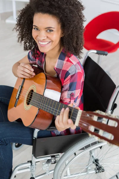 Senhora em cadeira de rodas tocando guitarra — Fotografia de Stock