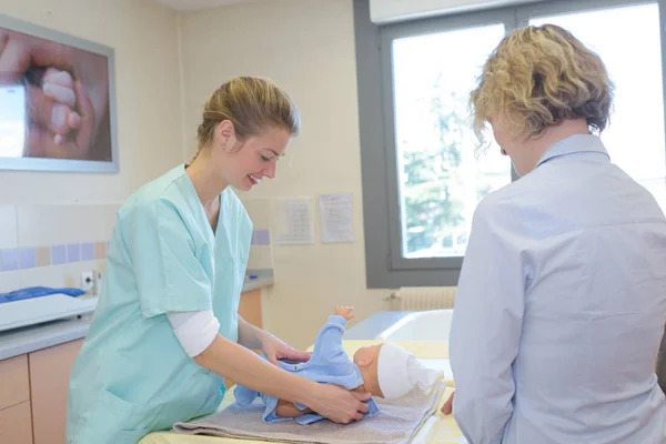 Медсестра, меняющая подгузник в больнице — стоковое фото