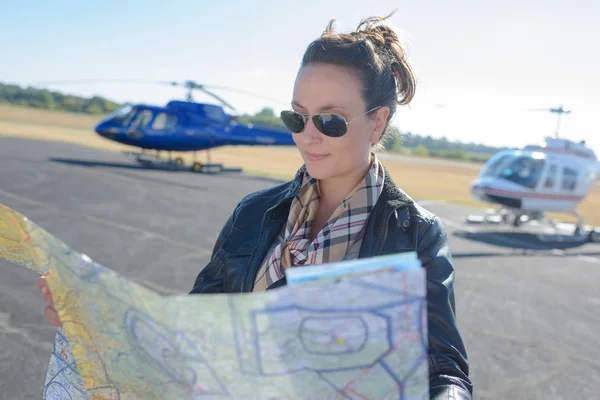 Jonge vrouw helikopter piloot lezen kaart — Stockfoto