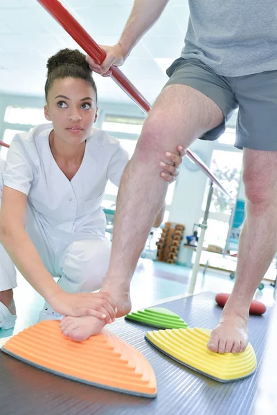 Patienten lära sig gå med kvinnlig sjukgymnast — Stockfoto