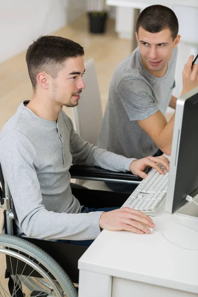 Estudiante y amigo en silla de ruedas escribiendo en pc — Foto de Stock