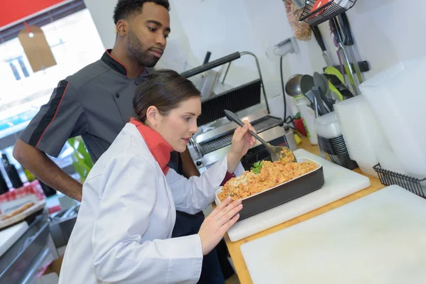 Woman pork butcher serving sausages to customer — Stock Photo, Image