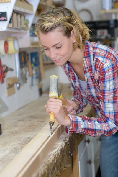 Glückliche Tischlerin, die Holz schnitzt — Stockfoto