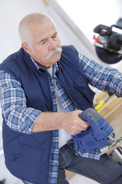 Builder using a jigsaw to cut the plywood — Stock Photo, Image