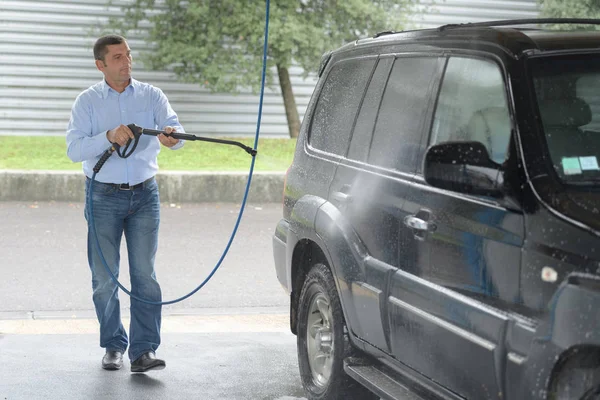 Man reinigen van de auto bij een auto-shop met waterdamp — Stockfoto