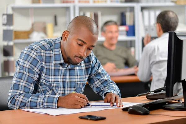 Homme assis au bureau travaillant sur les plans — Photo