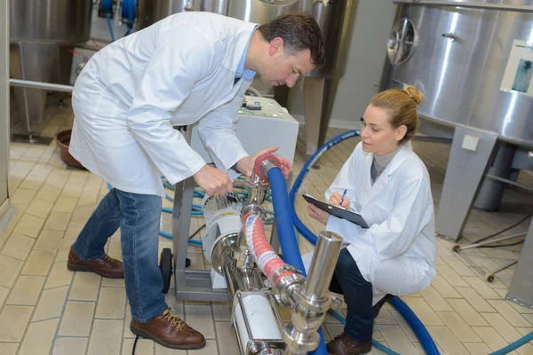 Trabajadores y trabajadoras en uniforme que trabajan en la fábrica —  Fotos de Stock