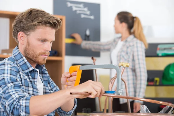 Man handsawing een metalen pijp — Stockfoto