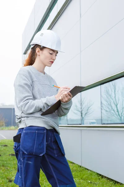 Frau inspiziert Außenfassade des Gebäudes — Stockfoto