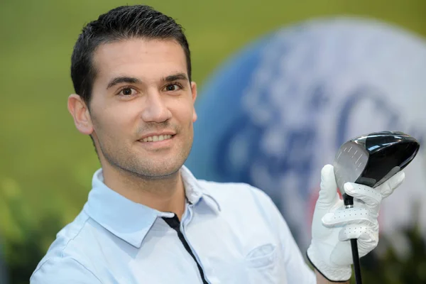 Ritratto di golfista in posa con una palla su un campo — Foto Stock