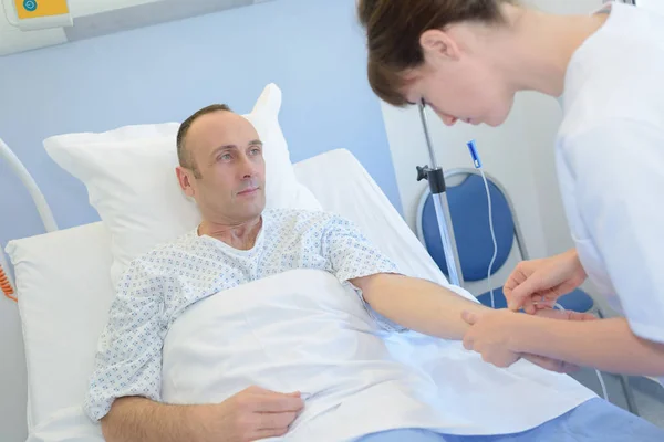 Inyectar a un paciente en una cama de hospital — Foto de Stock