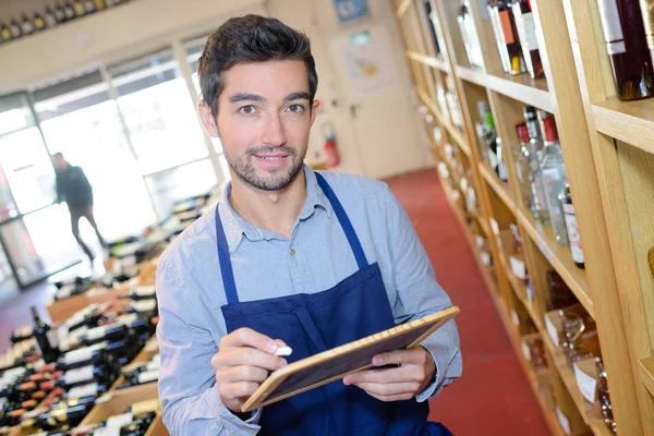 Säljare med inventering i vin butik — Stockfoto