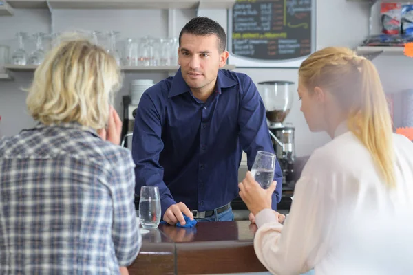 Gelukkig lachend vrouwen staan op bar en flirten met barman — Stockfoto