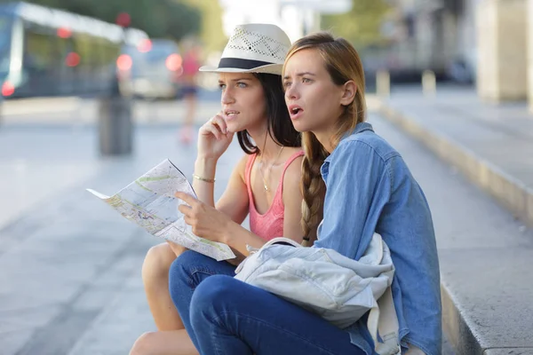 Perso e confuso ragazza amici in cerca di indicazioni sulla mappa — Foto Stock