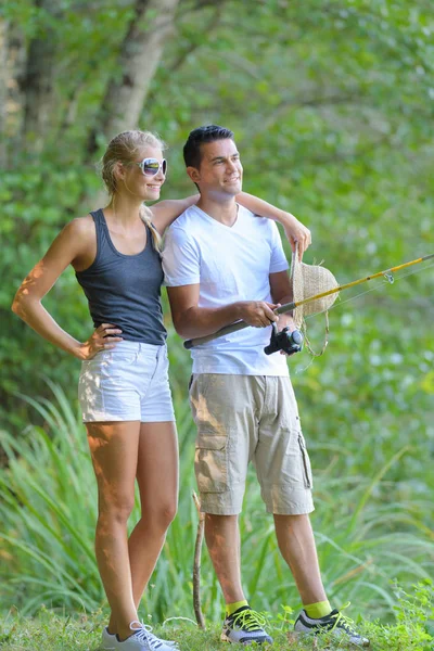 可爱的年轻夫妇在池塘边钓鱼 — 图库照片