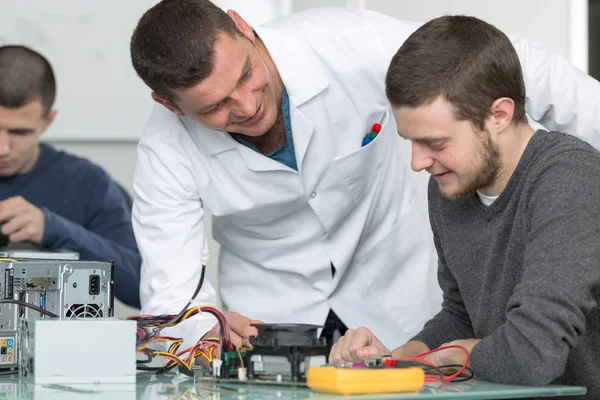 Junge Erwachsene reparieren Computerhardware in der Technikschule — Stockfoto