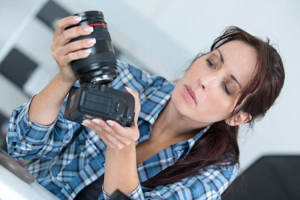 Fotografo femminile assemblaggio fotocamera — Foto Stock