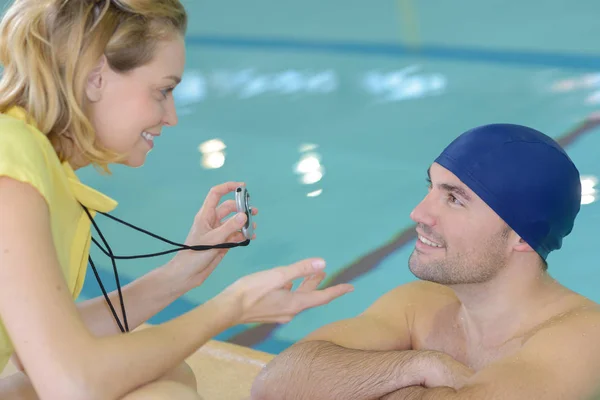 Пловец разговаривает со своим тренером у бассейна в центре досуга — стоковое фото