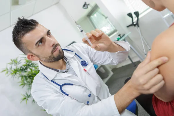 El médico pellizca el músculo deltoides listo para la inyección —  Fotos de Stock