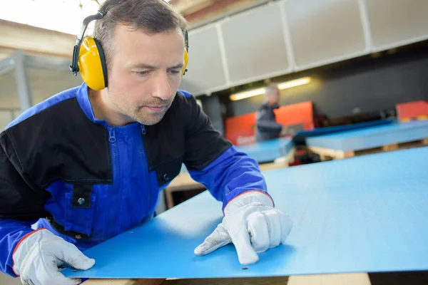 Werknemer mark kijken op vel materialen — Stockfoto