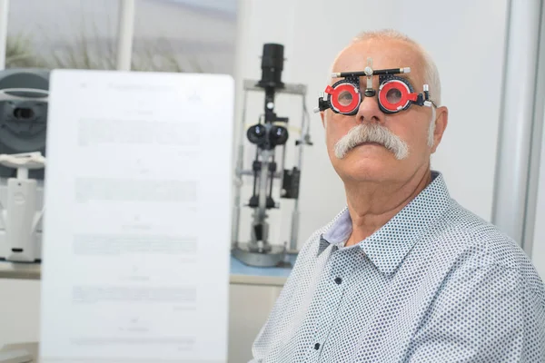 Senior man met een oog-onderzoek — Stockfoto