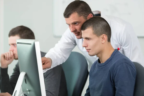 Leraar helpen it student met zijn werk — Stockfoto