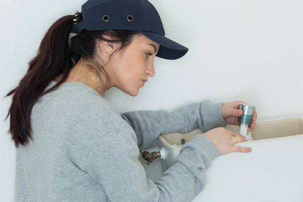 Vrouwelijke loodgieter vaststelling toilet flush — Stockfoto