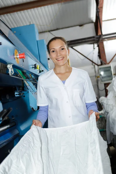 Portrait of woman folding laundry — Stok Foto