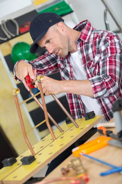 Man van de werknemer een metalen buizen snijden — Stockfoto