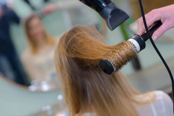 Cabelo da mulher sendo estilizado por cabeleireiro — Fotografia de Stock