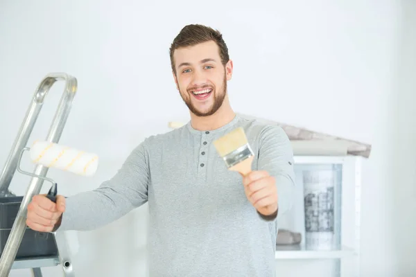 Porträt eines glücklichen Mannes beim Bemalen seines neuen Hauses — Stockfoto