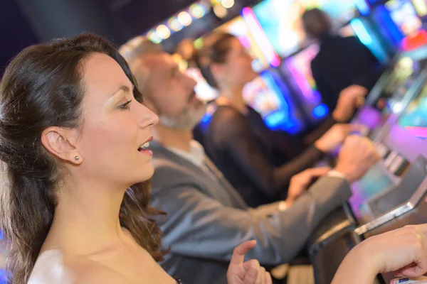 Grupp av personer som spelar slot och olika maskiner — Stockfoto