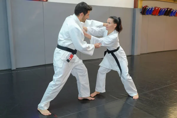 Woman and man judo fighters in sport hall — Stock Photo, Image