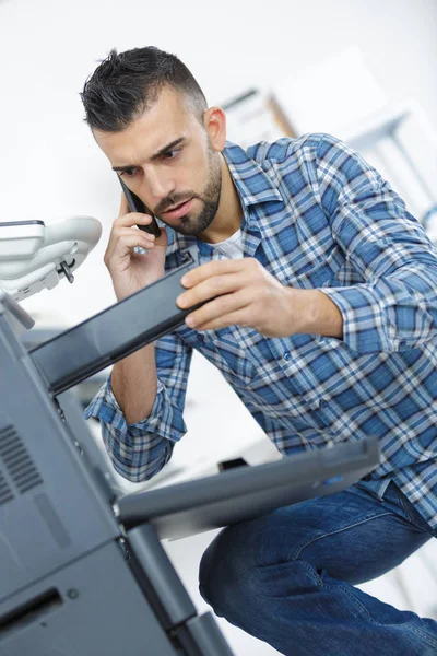 사무실 프린터를 해결 하는 동안에 전화 하는 남자 — 스톡 사진