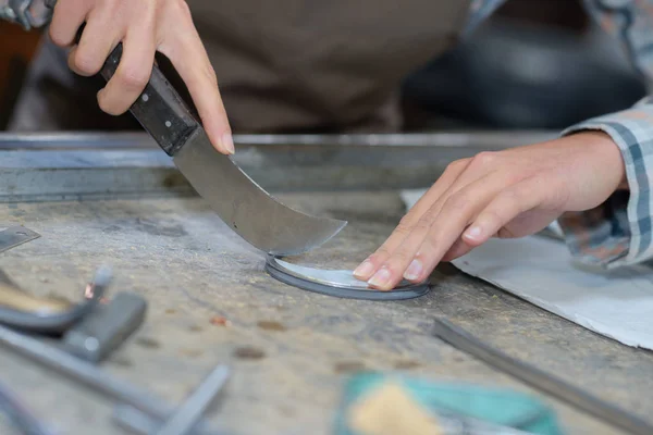 Curved knife being used by craft worker — Stock Photo, Image