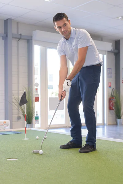 Homem jogando golfe indoor — Fotografia de Stock