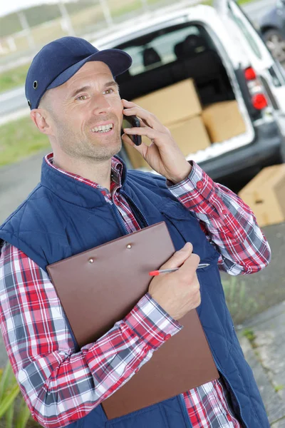Male worker in front truck using mobile phone — Stock Photo, Image