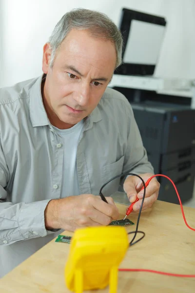 Mann testet die Leistung mit einem Voltmeter — Stockfoto