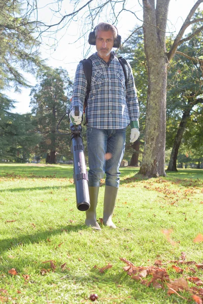 Man using a leaves blower — Stock Photo, Image