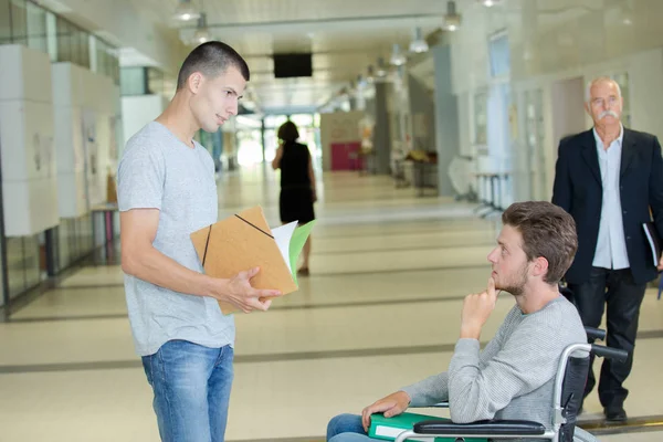 Vänner i universitet korridoren — Stockfoto